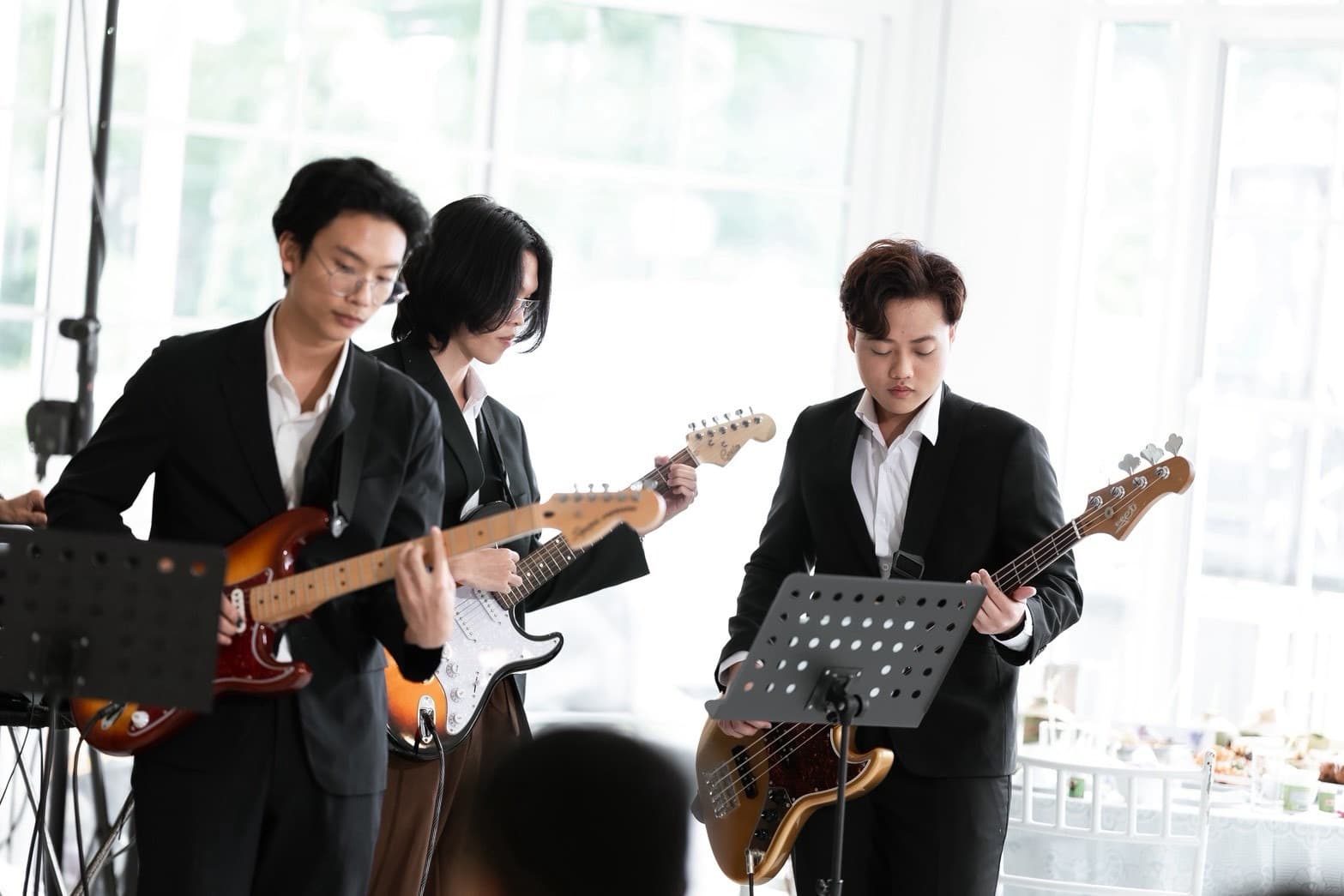 Three guitarists in dark suits performing during the ceremony