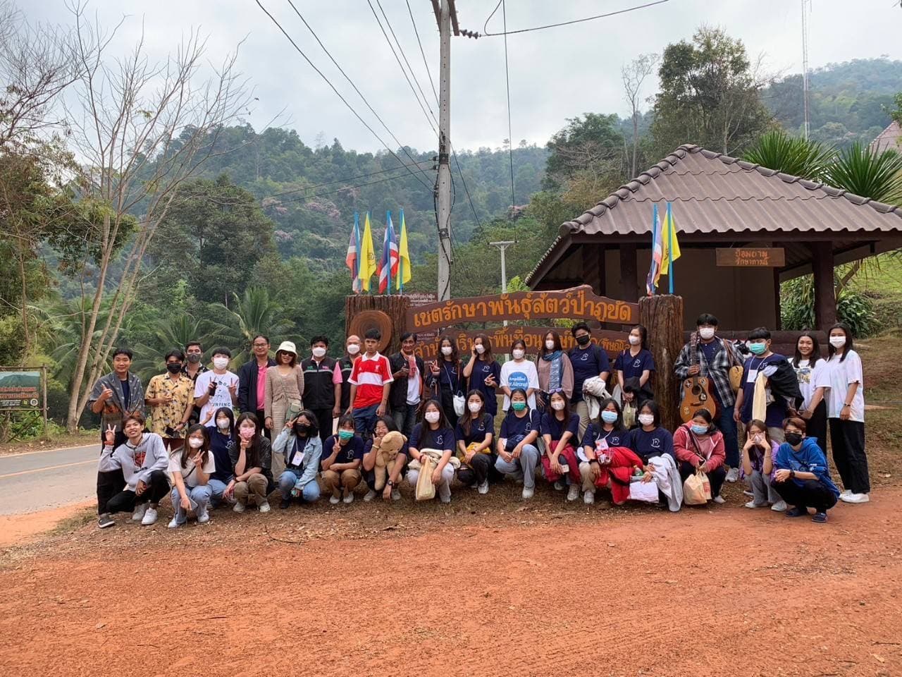 Volunteer group at the wooden entrance sign of Phu Khat Wildlife Sanctuary
